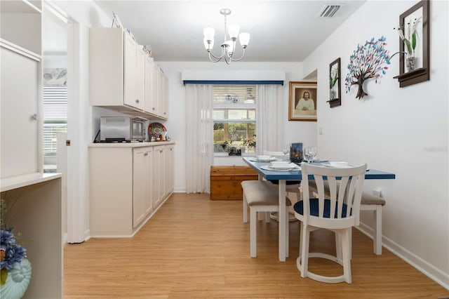 1804 W Shores Rd, Melbourne, FL 32935 - dining room featuring light wood-style floors, a chandelier, and baseboards
