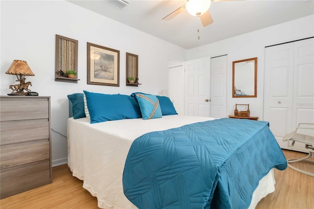 1804 W Shores Rd, Melbourne, FL 32935 - bedroom with light wood finished floors, a ceiling fan, and two closets