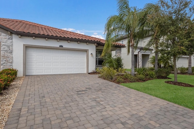 2532 Avolet Ct, Lakewood Ranch, FL 34211 - mediterranean / spanish-style home with stucco siding, stone siding, a garage, decorative driveway, and a tile roof