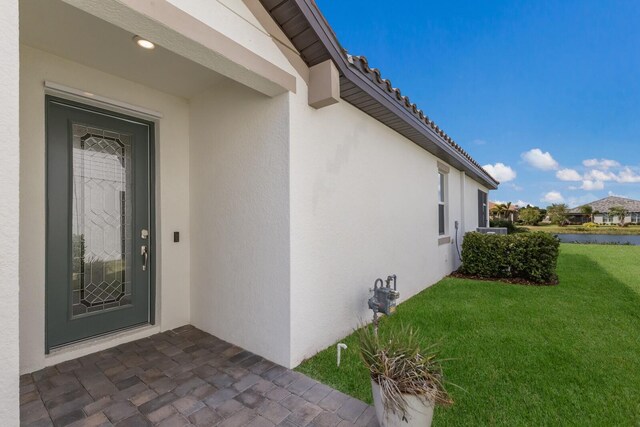 2532 Avolet Ct, Lakewood Ranch, FL 34211 - property entrance featuring stucco siding, a yard, and a water view