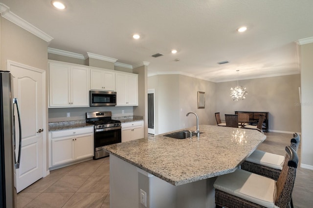 2532 Avolet Ct, Lakewood Ranch, FL 34211 - kitchen featuring appliances with stainless steel finishes, a sink, white cabinets, light stone countertops, and ornamental molding