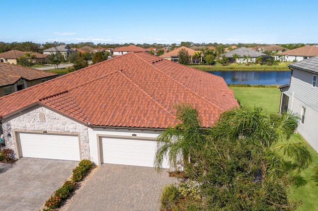 2532 Avolet Ct, Lakewood Ranch, FL 34211 - view of front facade featuring a tiled roof, a residential view, a water view, stone siding, and driveway