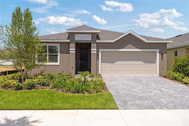 499 Silver Palm Dr, Haines City, FL 33844 - view of front of home featuring stucco siding, driveway, an attached garage, and a shingled roof