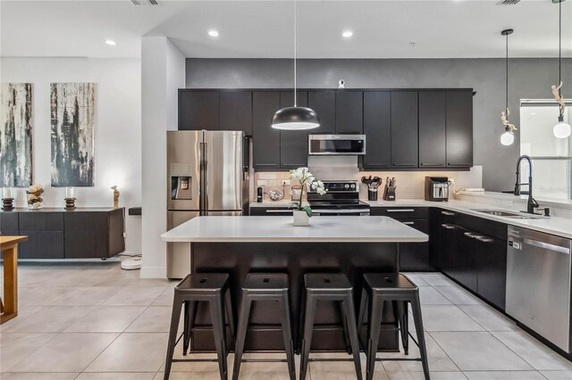 8160 Iron Mountain Trl, Windermere, FL 34786 - kitchen featuring stainless steel appliances, a sink, dark cabinets, light countertops, and a kitchen breakfast bar