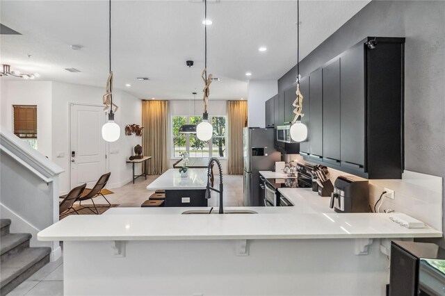 8160 Iron Mountain Trl, Windermere, FL 34786 - kitchen featuring stainless steel appliances, a sink, light tile patterned floors, light countertops, and a kitchen breakfast bar