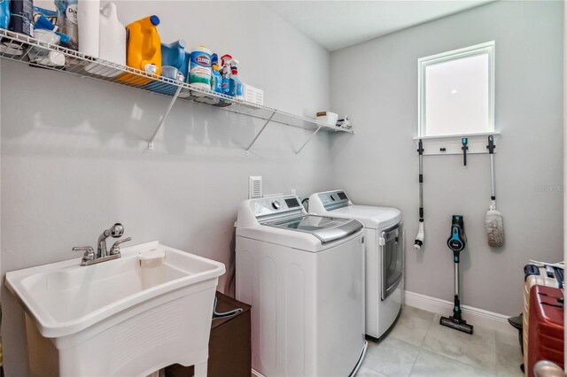 8160 Iron Mountain Trl, Windermere, FL 34786 - clothes washing area with washing machine and clothes dryer, baseboards, and light tile patterned floors