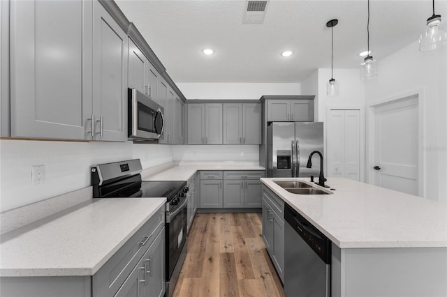 7104 N Maltese Dr, Citrus Springs, FL 34433 - kitchen with appliances with stainless steel finishes, gray cabinets, a sink, light wood-style floors, and recessed lighting