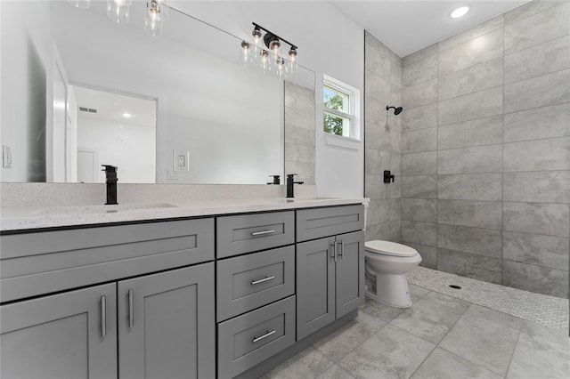 7104 N Maltese Dr, Citrus Springs, FL 34433 - bathroom featuring double vanity, a tile shower, toilet, and recessed lighting