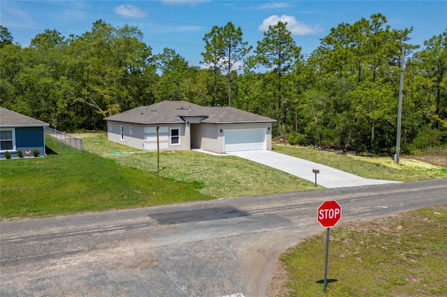 7104 N Maltese Dr, Citrus Springs, FL 34433 - view of front facade featuring driveway, a garage, a front lawn, and a view of trees