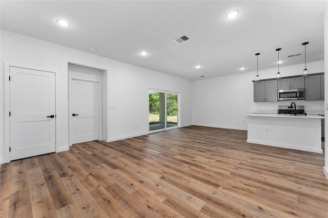 7104 N Maltese Dr, Citrus Springs, FL 34433 - unfurnished living room with light wood-type flooring and recessed lighting