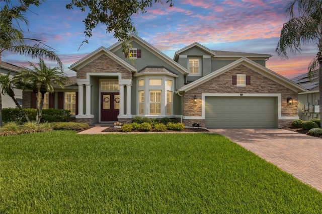 724 Duff Dr, Winter Garden, FL 34787 - view of front of house with stucco siding, decorative driveway, stone siding, and a garage