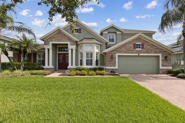 724 Duff Dr, Winter Garden, FL 34787 - craftsman-style house with stucco siding, decorative driveway, stone siding, a garage, and a front lawn