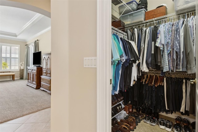 724 Duff Dr, Winter Garden, FL 34787 - spacious closet featuring arched walkways, carpet floors, a raised ceiling, and tile patterned flooring