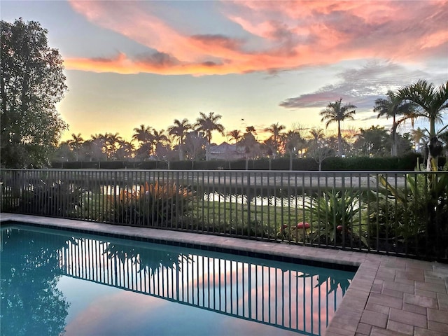 14835 Dockside Ln, Naples, FL 34114 - pool at dusk featuring fence