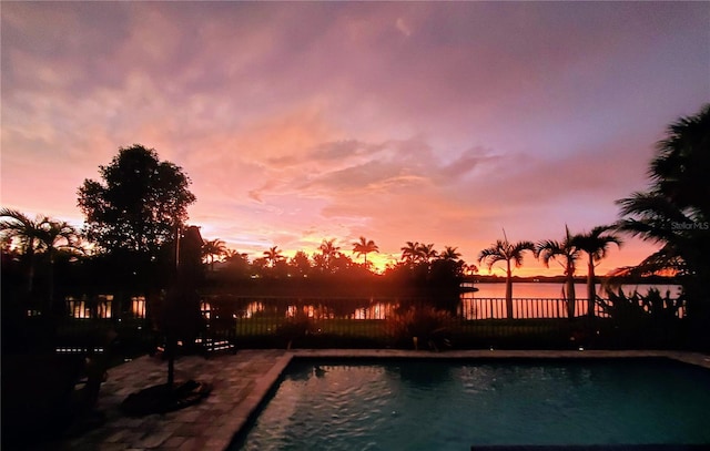 14835 Dockside Ln, Naples, FL 34114 - pool at dusk with fence, a water view, and a patio