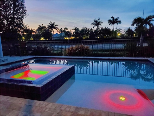 14835 Dockside Ln, Naples, FL 34114 - pool at dusk with a fenced backyard and a pool with connected hot tub
