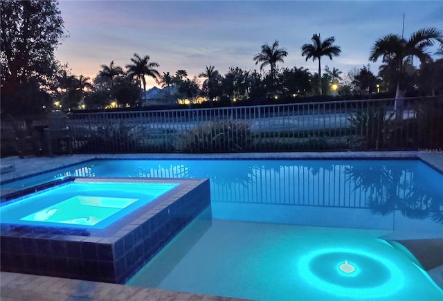 14835 Dockside Ln, Naples, FL 34114 - pool at dusk featuring fence and a pool with connected hot tub