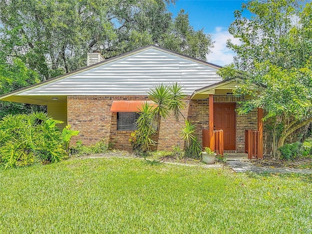 1591 Revere Ln, Daytona Beach, FL 32117 - rear view of property featuring a yard, brick siding, and a chimney