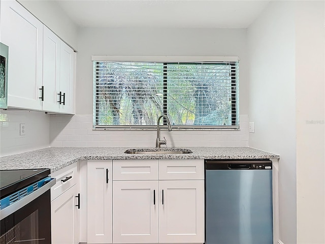 1591 Revere Ln, Daytona Beach, FL 32117 - kitchen featuring dishwasher, a sink, backsplash, black range with electric stovetop, and white cabinetry
