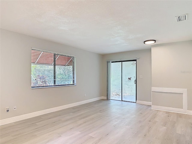 1591 Revere Ln, Daytona Beach, FL 32117 - empty room featuring light wood-style flooring, baseboards, and a textured ceiling