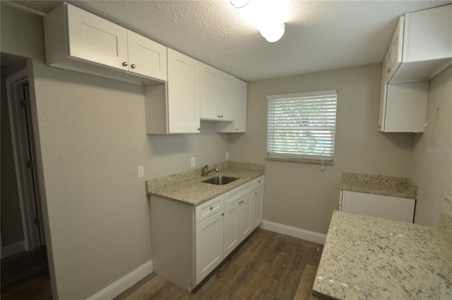 1238 Conley St, Orlando, FL 32805 - kitchen with a sink, dark wood-type flooring, baseboards, and white cabinets