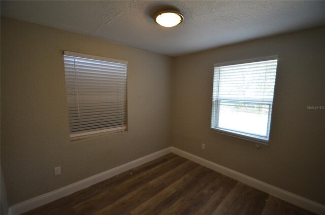 1238 Conley St, Orlando, FL 32805 - spare room featuring a textured ceiling, dark wood-type flooring, and baseboards