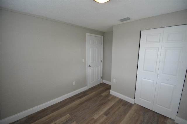 1238 Conley St, Orlando, FL 32805 - unfurnished bedroom featuring dark wood-style flooring, a closet, and baseboards