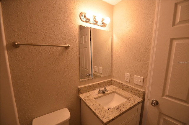 1238 Conley St, Orlando, FL 32805 - bathroom featuring a textured wall, toilet, and vanity