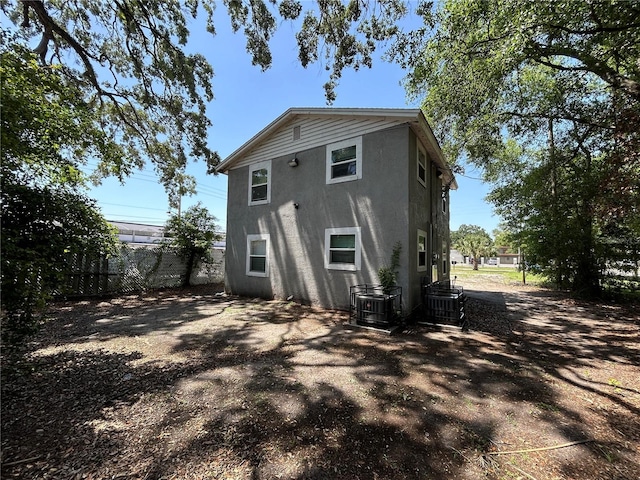 1238 Conley St, Orlando, FL 32805 - rear view of house with stucco siding, fence, and central AC unit