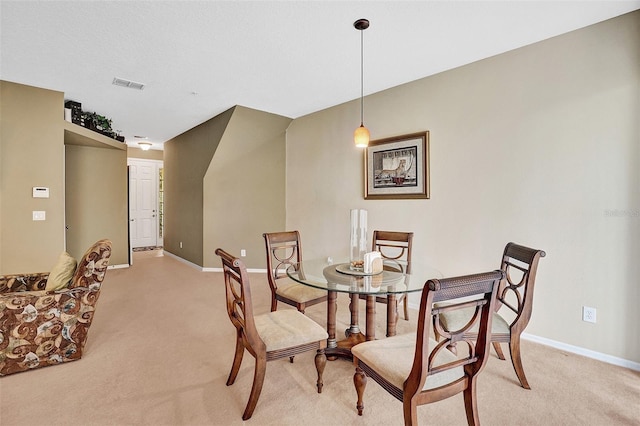 dining room with light colored carpet and baseboards