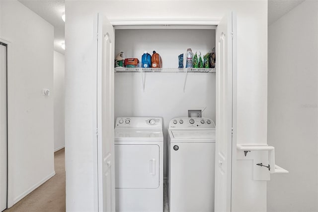 laundry room featuring washing machine and dryer and light carpet