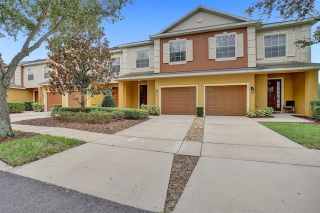 townhome / multi-family property featuring stucco siding, driveway, and an attached garage