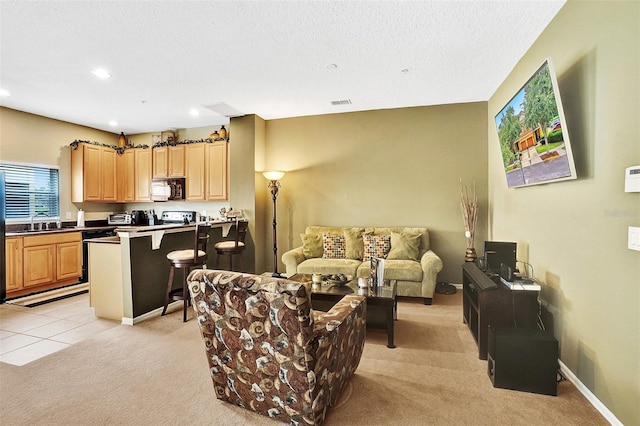 living area featuring light carpet, recessed lighting, and a textured ceiling