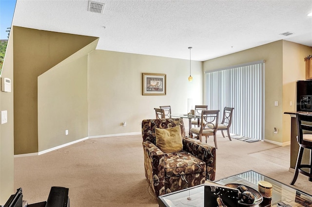 living room with light colored carpet, baseboards, and a textured ceiling