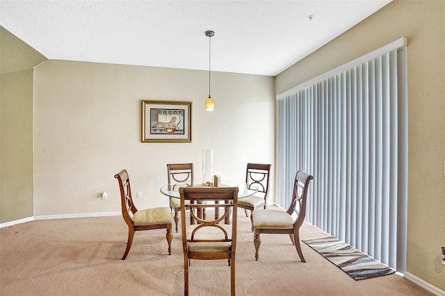 carpeted dining space with baseboards