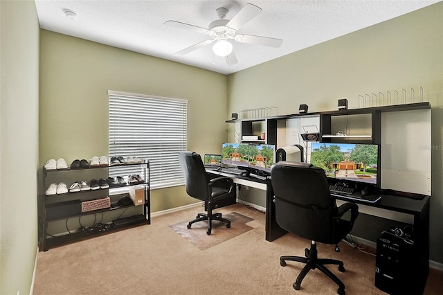 carpeted home office with a ceiling fan and baseboards