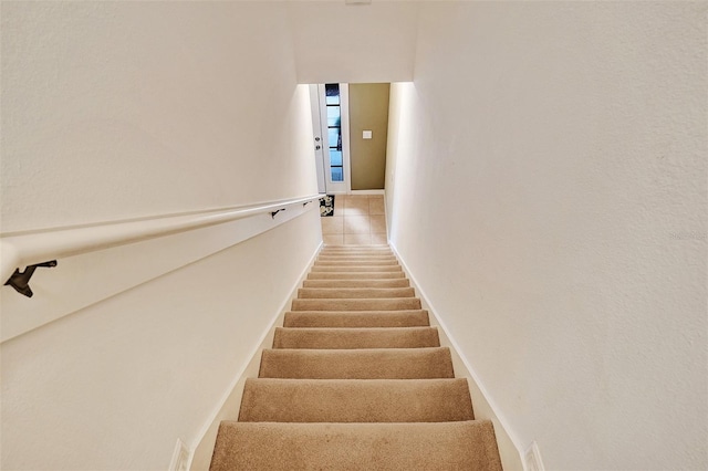 staircase featuring tile patterned flooring