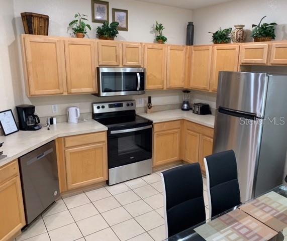 446 Summer Place Loop, Clermont, FL 34714 - kitchen featuring appliances with stainless steel finishes, light brown cabinets, light countertops, and light tile patterned floors