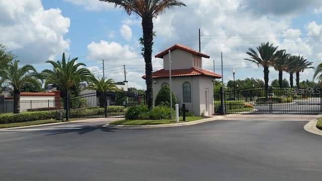 446 Summer Place Loop, Clermont, FL 34714 - view of asphalt road with a gate, a gated entry, curbs, and street lights