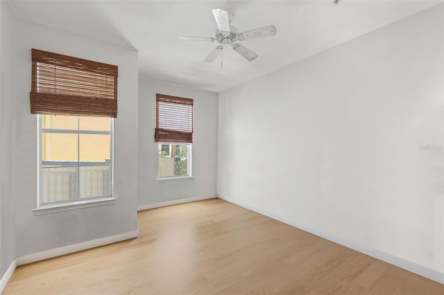 empty room with wood finished floors, baseboards, and ceiling fan