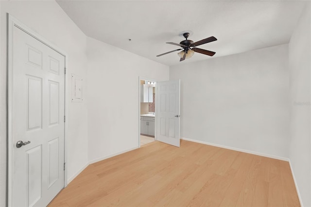 unfurnished room with ceiling fan, light wood finished floors, and baseboards