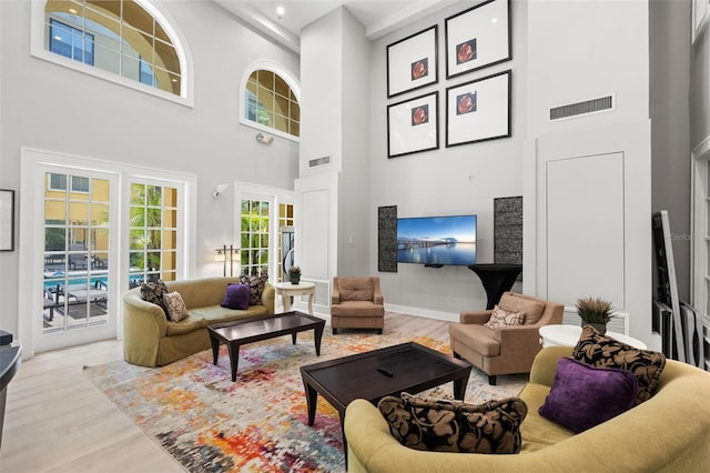 living area featuring a towering ceiling and wood finished floors