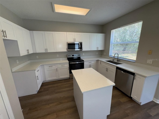 3707 Andover Cay Blvd, Orlando, FL 32825 - kitchen with appliances with stainless steel finishes, a sink, a kitchen island, and dark wood-style floors