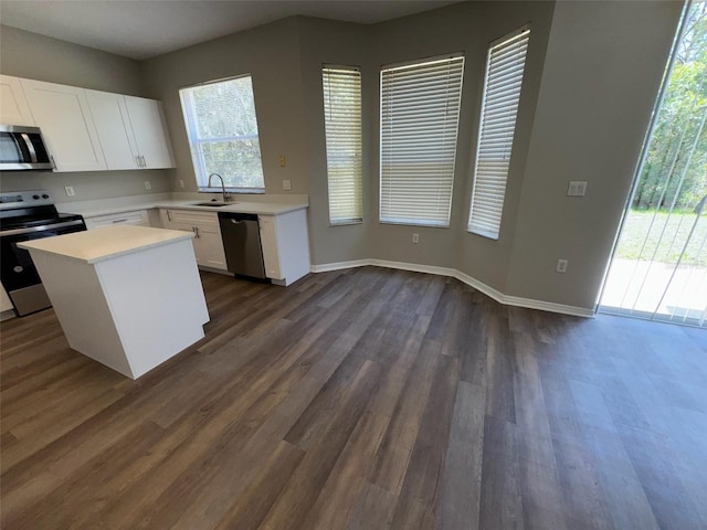 3707 Andover Cay Blvd, Orlando, FL 32825 - kitchen featuring stainless steel appliances, a sink, light countertops, white cabinetry, and dark wood-style floors