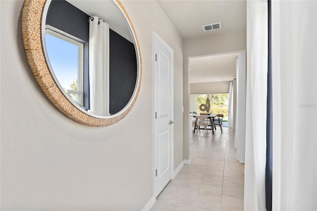 hallway featuring baseboards and light tile patterned floors