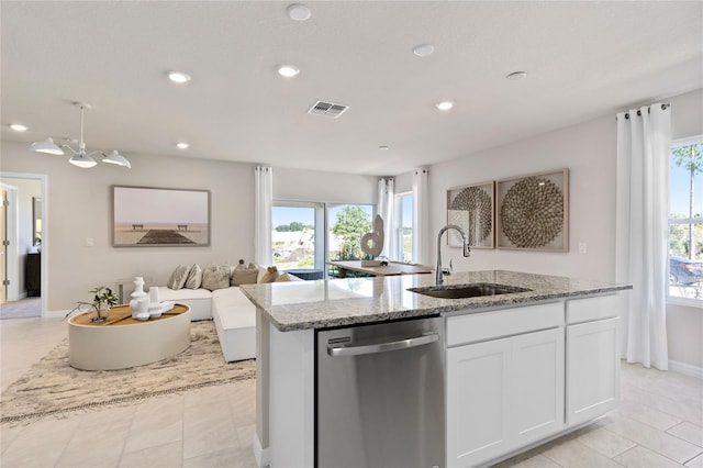 kitchen with dishwasher, a sink, open floor plan, a center island with sink, and white cabinetry