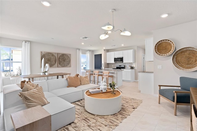 living area with a chandelier, light tile patterned flooring, and recessed lighting
