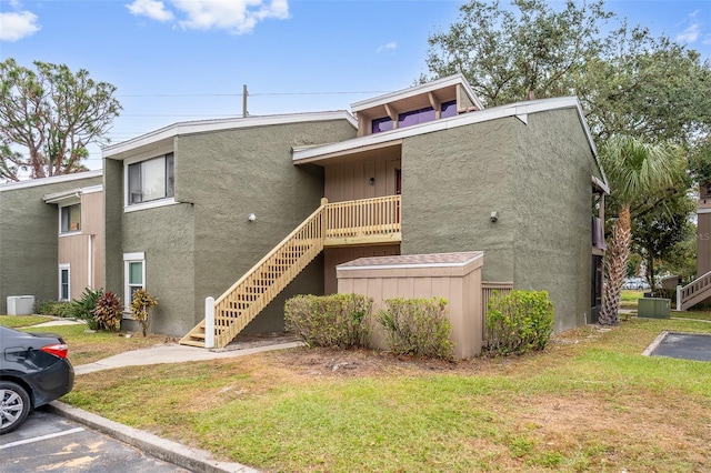 5071 Eaglesmere Dr Unit C01, Orlando, FL 32819 - view of property featuring uncovered parking, stairs, and cooling unit