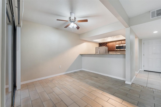 5071 Eaglesmere Dr Unit C01, Orlando, FL 32819 - kitchen with stainless steel appliances, ceiling fan, baseboards, and brown cabinets