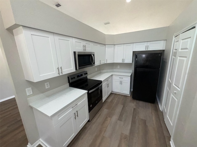 7507 Sandstone Dr, Orlando, FL 32836 - kitchen with appliances with stainless steel finishes, light countertops, dark wood-style flooring, and white cabinetry